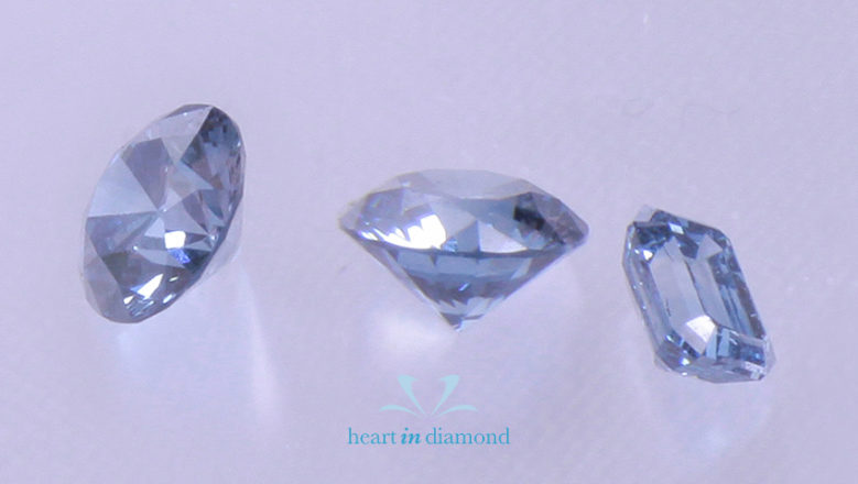 Two bluw round cut diamonds and one emerald cut cremation diamond with the heart in diamond logo