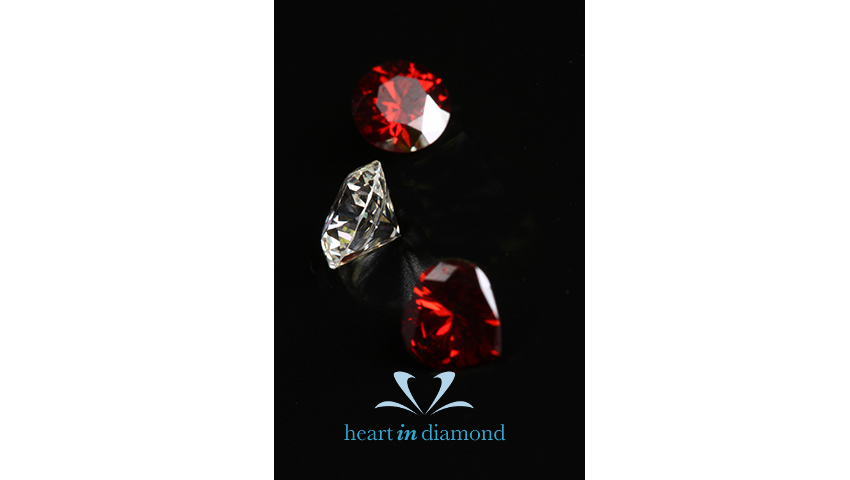 Two red brilliant cut diamonds and one white brilliant cut diamond